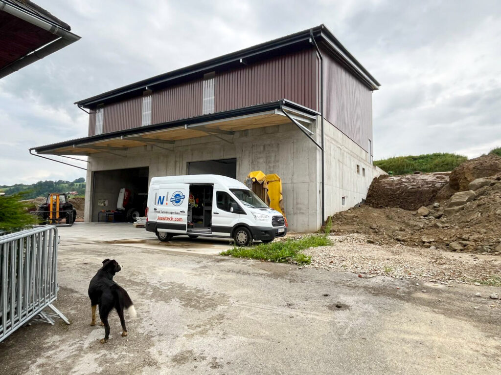 Auto steht vor Maschinenhalle einer Landwirtschaft