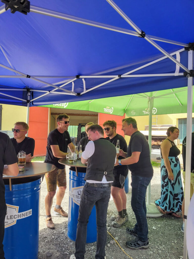 Team steht um Tisch und trinkt Getränke